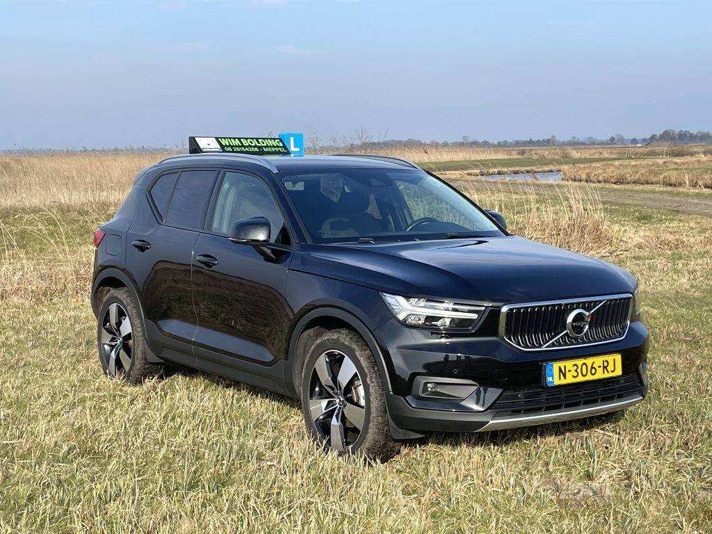 De zwarte Volvo lesauto van Autorijschool Wim Bolding met daklichtbak